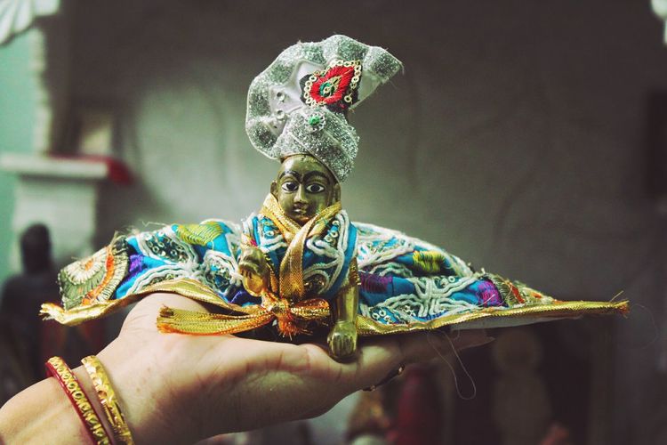 Cropped hand of woman holding statue at home