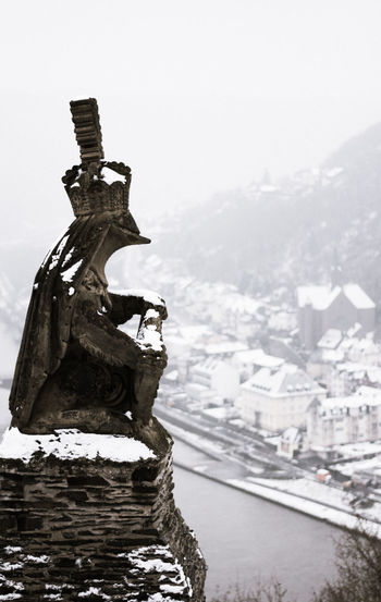 Close-up of statue on snow against sky