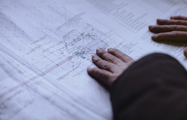 Close-up of engineer working touching blueprint