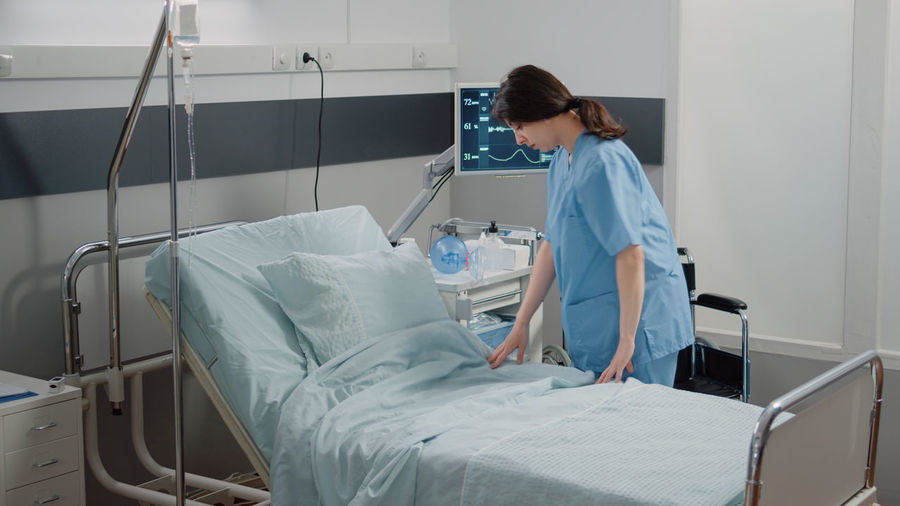 Nurse setting bed in hospital