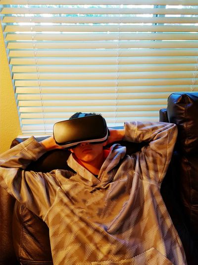 High angle view of boy wearing virtual reality simulator at home