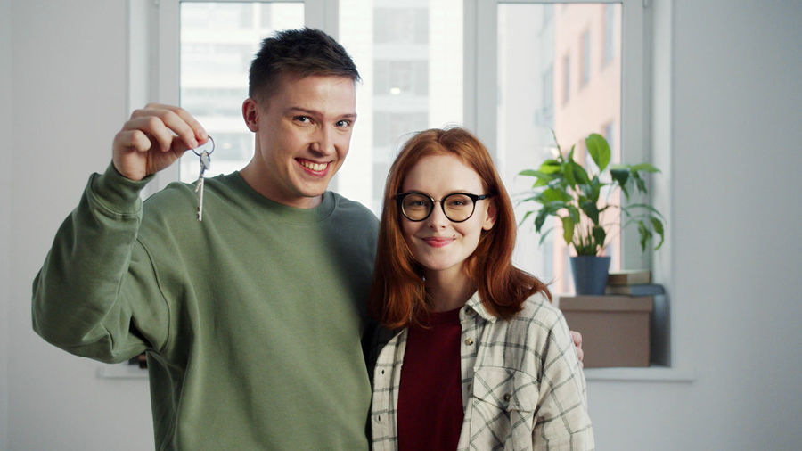 Portrait of smiling young couple showing house keys