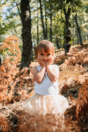 Portrait of smiling girl standing in forest