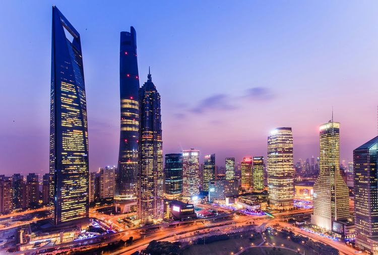 Illuminated buildings in city against sky