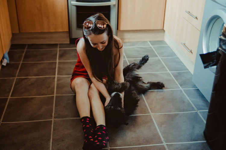 Woman playing with dog at home