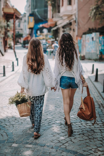 Two hippie friends woman walking on the street in the summer. friendship and freedom concept