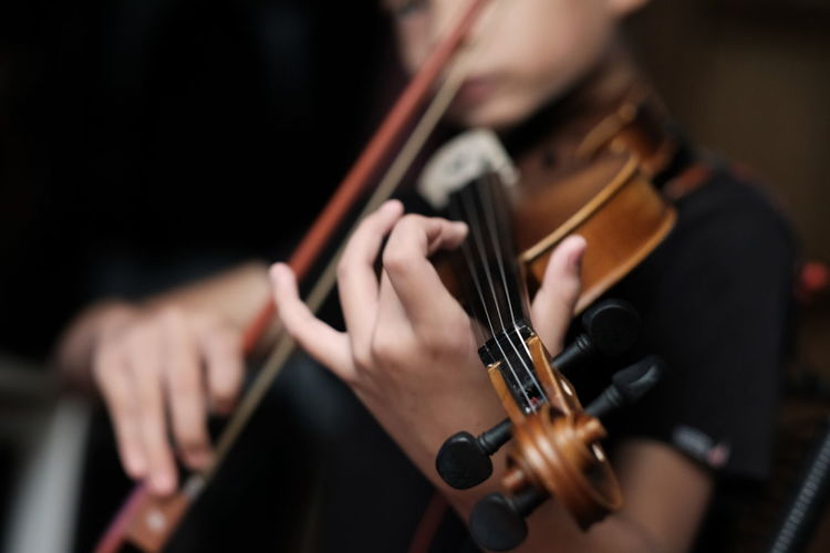 Midsection of man playing guitar