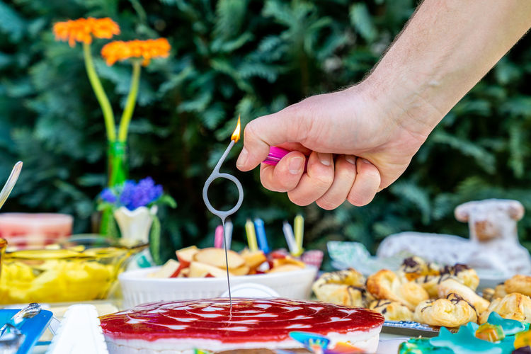 Hand holding birthday cake on table