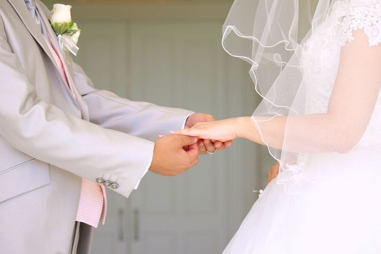 Close-up of bride and groom holding hands
