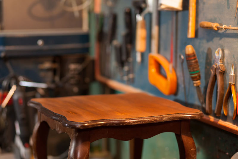 Wooden table by work tools at workshop