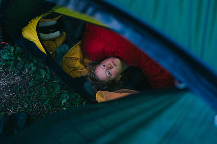 High angle view of woman lying in tent