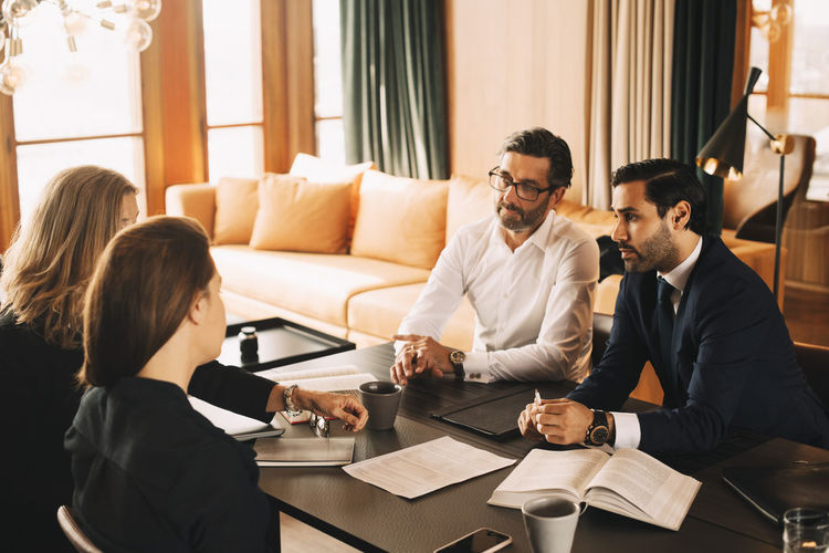 Male and female legal coworkers planning in meeting at board room