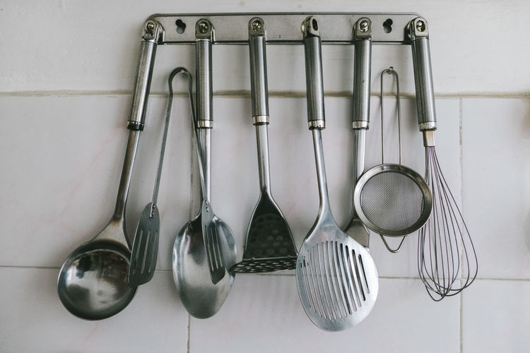Utensils hanging on hook against wall in kitchen