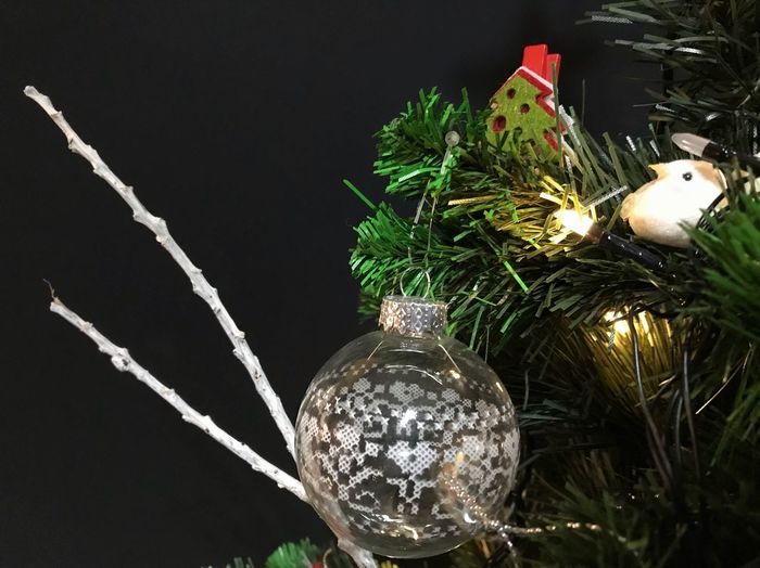 Close-up of illuminated light bulb hanging on christmas tree