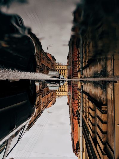 Upside down image of buildings and cars reflection in puddle