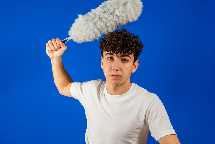 Portrait of young man against blue background