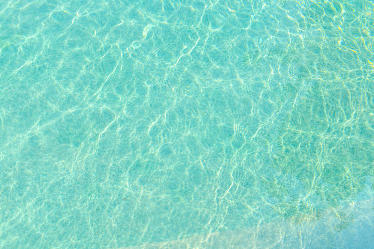Swimming pool blue water with a wave and sunlight reflection effect
